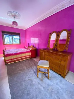 a pink bedroom with a bed and a dresser and mirrors at Nice Apartment in Marrakesh in Marrakech