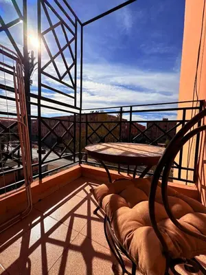 a balcony with a table and a chair on a balcony at A haven of light & sweetness in Marrakech