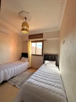 two beds in a room with a window at A haven of light & sweetness in Marrakech