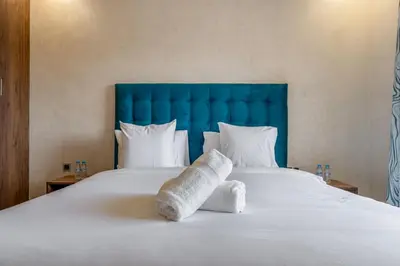 a large white bed with a blue headboard and pillows at Stylish Apartment with Balcony view & Free Parking in Marrakech
