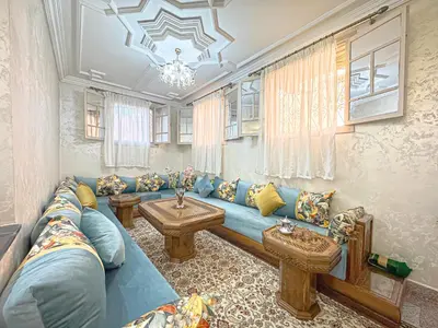 a living room with a blue couch and a table at Havre de calme - Cour & 2 chambres in Marrakech