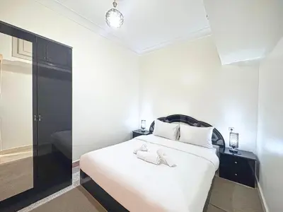 a bedroom with a white bed with two towels on it at Havre de calme - Cour & 2 chambres in Marrakech