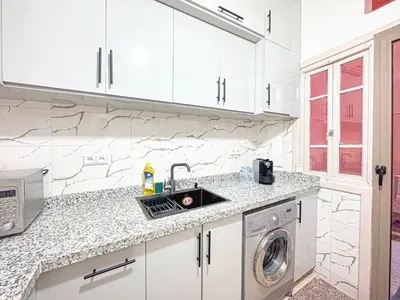 a kitchen with a sink and a washing machine at Havre de calme - Cour & 2 chambres in Marrakech