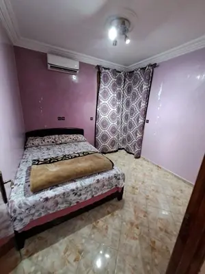 a bedroom with a bed and a purple wall at Happy space in Marrakech