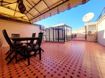 a room with a table and chairs on a balcony at Riad Privatif 250m2 près Médina-palais Royal in Marrakech