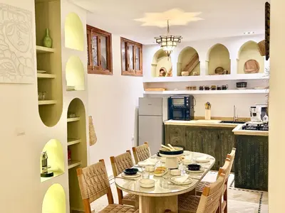 a dining room with a table and chairs in a kitchen at Riad des bibouches pool breakfast private in Marrakech