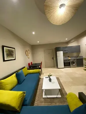 a living room with a blue couch and yellow pillows at Red city charm - city center apartment in Marrakech
