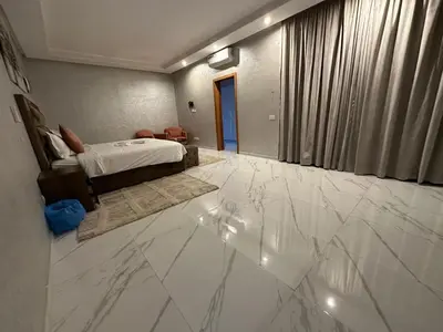 a bedroom with a bed and a white marble floor at Villa à la palmeraie in Marrakech