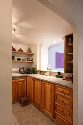 a kitchen with wooden cabinets and a window at Riad Cosy in Marrakech