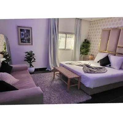 a bedroom with two beds and a couch at Villa Maison Dar Sukar in El Caïd Omar
