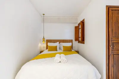 a bedroom with a white bed with two white slippers at Riad Mimouna - Rooftop view & Breakfast included - 4 Rooms - Fully private in Marrakech