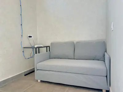 a couch sitting in a room with a phone at Lovely studio 4th floor No Elevator in El Gouassem