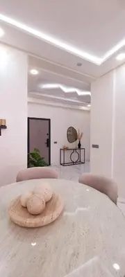 a white room with a table with two chairs at Moderne appart NEUF Proche Aéroport et Gueliz in Marrakech