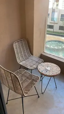 two chairs and a table next to a window at Beautiful Apartment in Guéliz Pools & Jacuzzi in Marrakech