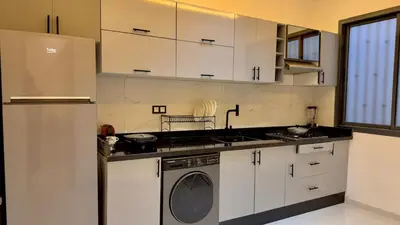 a kitchen with white cabinets and a washing machine at NEW 2 Bedrooms Apartment 15 min from City Center Marrakech in Marrakech