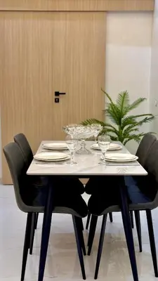 a white table with black chairs and wine glasses at NEW 2 Bedrooms Apartment 15 min from City Center Marrakech in Marrakech