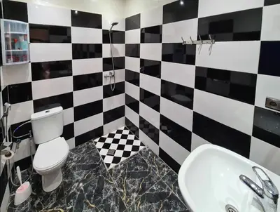a bathroom with a black and white checkered wall at Riad Le Sultana in Marrakech