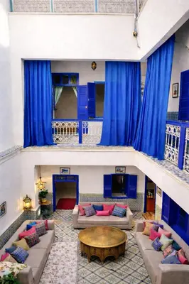 a living room with blue curtains and couches at Riad Le Sultana in Marrakech