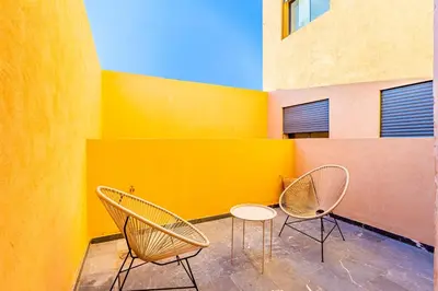 two chairs and a table in front of a yellow wall at Urban, New 2 BR Apartment in Marrakech