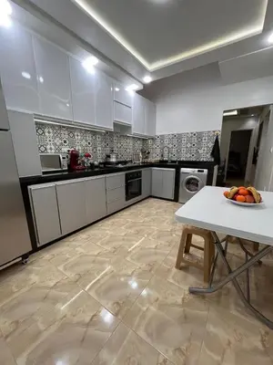 a kitchen with a table with a bowl of fruit on it at cozy and spacious apartment in Marrakech