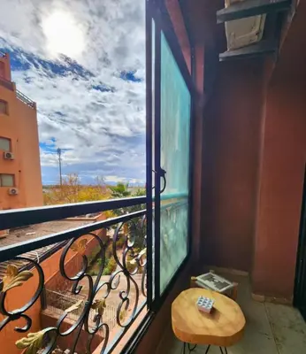a balcony with a wooden table and a window at Caprice Palace Residence Bella Anima in Marrakech