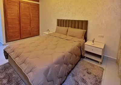 a bedroom with a large bed and a night stand at apparemment 35 in Marrakech