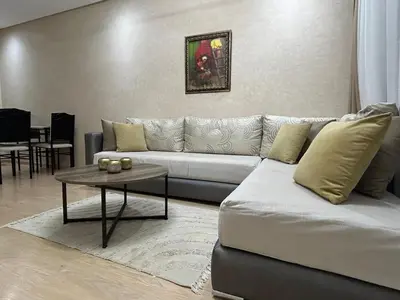 a living room with a couch and a table at Prestigia Appartment Golf & 3 Pools in Marrakech