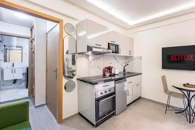 a kitchen with white cabinets and a table and a table at Studio chic et cosy au cœur de Guéliz in Marrakech