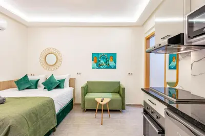 a hotel room with a bed and a green chair at Studio chic et cosy au cœur de Guéliz in Marrakech