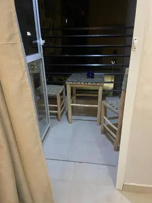 a balcony with a table and chairs and a ladder at Cozy flat near airport in Marrakech