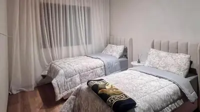 a bedroom with two beds and a window at Jnane El Ali 3 in Marrakech
