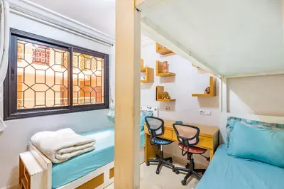 a room with a bed and two chairs and a desk at Oasis Familiale Marrakech Piscine & Résidence Sécurisée in Marrakech