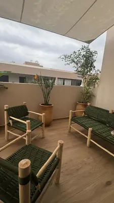 a balcony with two green benches on a roof at Cozy apartment Kenza Menara Garden 2 - 2 rooms in Marrakech