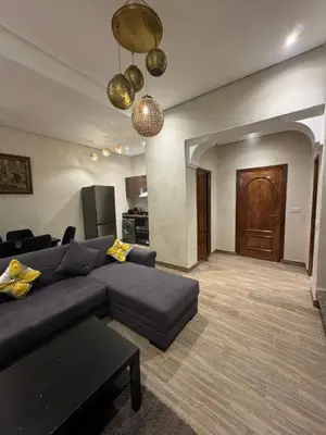 a living room with a blue couch and a kitchen at Duplex Bahia Palace in Marrakech