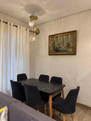 a dining room with a black table and chairs at Duplex Bahia Palace in Marrakech