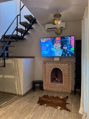 a living room with a fireplace with a flat screen tv at Duplex Bahia Palace in Marrakech
