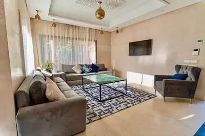 a living room with a couch and a table at Villa Akenza piscine privée Marrakesh in El Rhechat