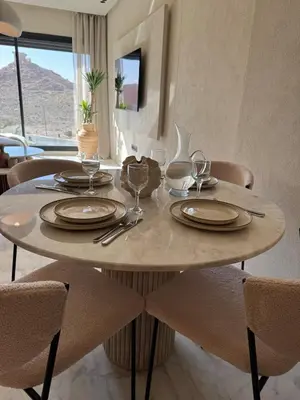 a dining table with plates and wine glasses on it at Refined apartment with rooftop pool in Marrakech