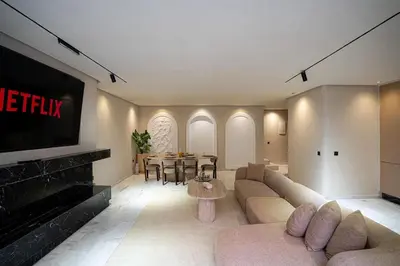 a living room with a couch and a tv at Spacious duplex Private HEATED pool Jacuzzi in Marrakech