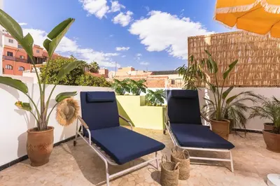 two chairs sitting on a patio with plants at Lalla Homes 369 in Marrakech