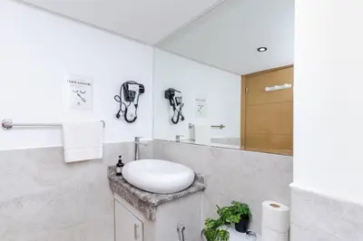 a white bathroom with a sink and a mirror at Lalla Homes 369 in Marrakech