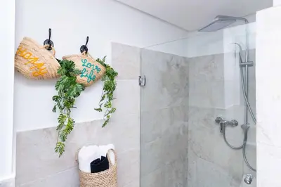 a bathroom with a walk in shower and baskets at Lalla Homes 369 in Marrakech