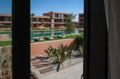 a view of a swimming pool from a window at Appartement 2 chambres avec grand jardin Noria Golf in Marrakech