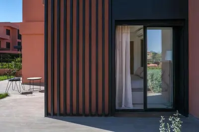 a sliding glass door of a building with a couch outside at Appartement 2 chambres avec grand jardin Noria Golf in Marrakech