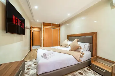 a bedroom with a large white bed in a room at Spacious & Modern Guéliz Apart - 5 min to Airport in Marrakech