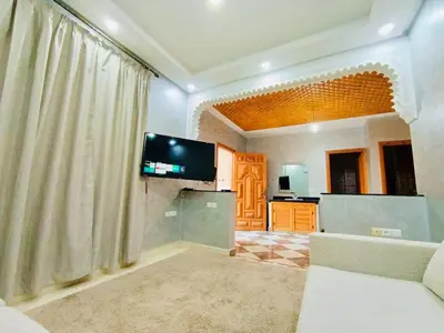 a living room with a television and a kitchen at Nice apart wi-fi 3rd floor in El Gouassem