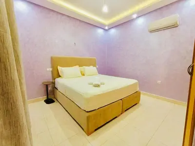 a bedroom with a bed in a purple wall at Nice apart wi-fi 3rd floor in El Gouassem