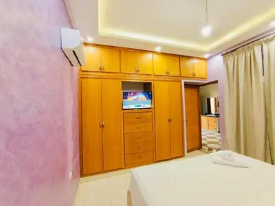 a bedroom with wooden cabinets and a tv in it at Nice apart wi-fi 3rd floor in El Gouassem