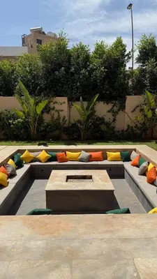 a seating area with colorful pillows and a table at Exceptional Villa Noria Golf in Marrakech