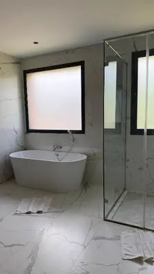 a white bathroom with a tub and a window at Luxury villa Noria golf club in Marrakech